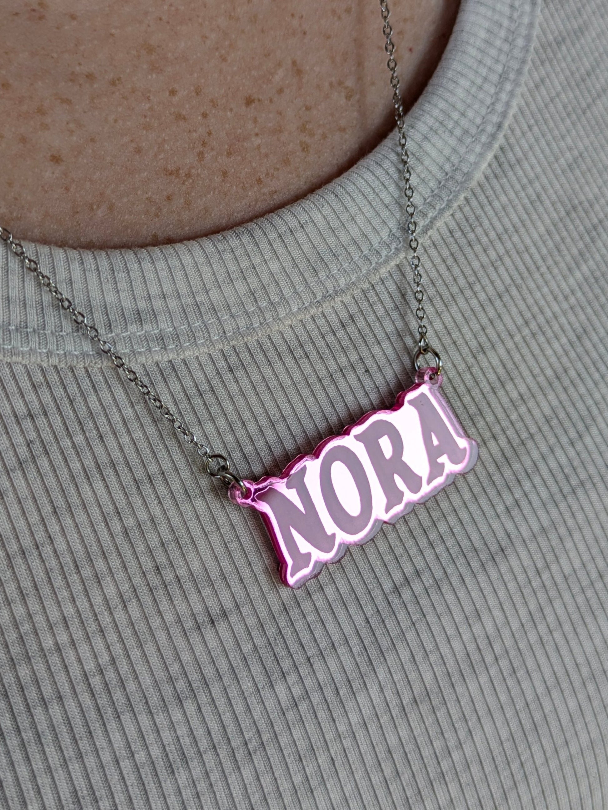 shiny pink acrylic necklace being worn by a woman.