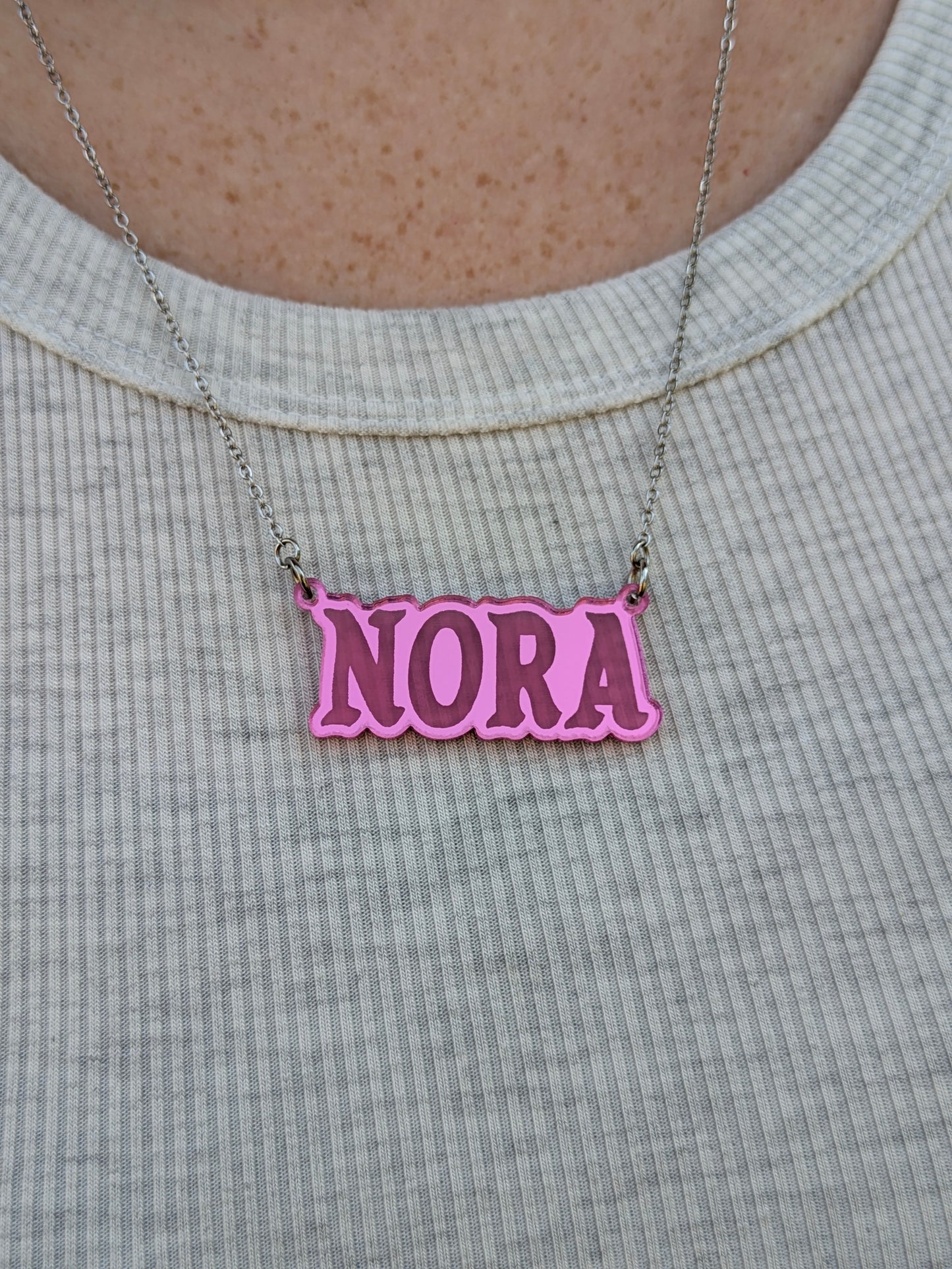 shiny pink acrylic necklace being worn by woman from the front view.