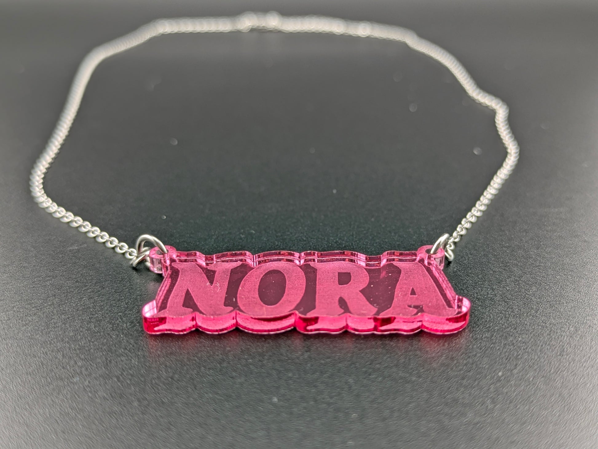 silver connector chain attached to a pink acrylic pendant.